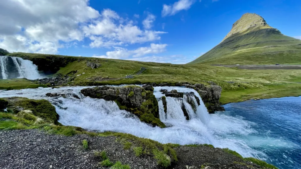 Vodopád Kirkjufellsfoss s několika proudy vody před výraznou horou Kirkjufell na Islandu.