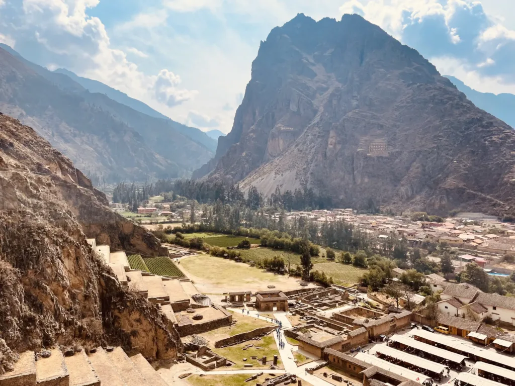 Pohled z inckých teras na město Ollantaytambo a strmé horské údolí v Peru