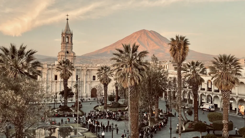 Palmy na náměstí Plaza de Armas v Arequipě s koloniální katedrálou a sopkou Misti v pozadí.