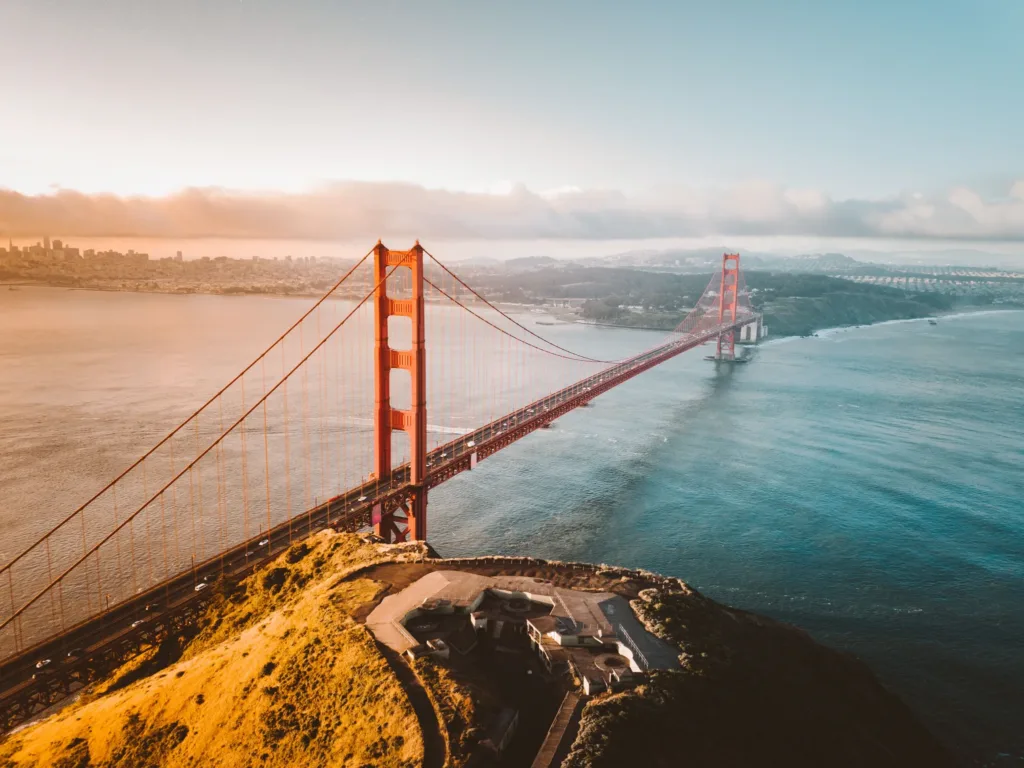 Pohled z výšky na most Golden Gate Bridge nad zálivem v San Franciscu při západu slunce