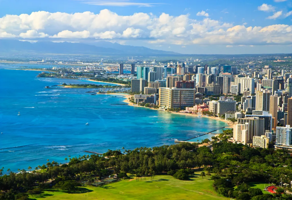 Pohled z výšky na tyrkysové moře, pláž Waikiki a hotely v Honolulu na ostrově Oahu.