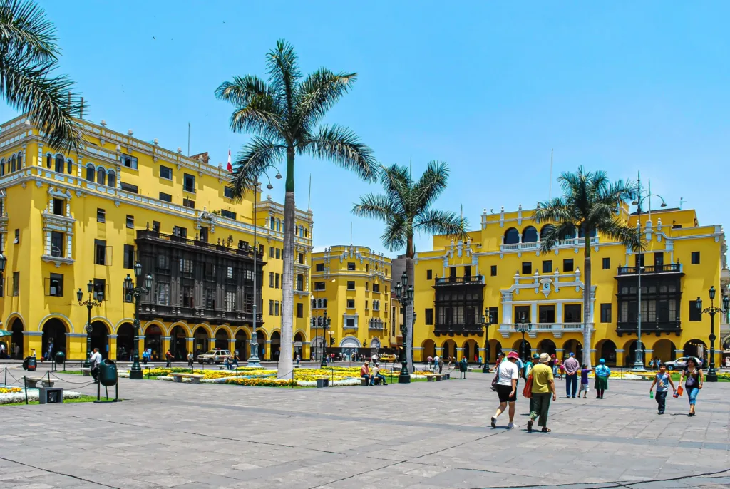 Palmy a žluté koloniální budovy na náměstí Plaza Mayor v historickém centru Limy