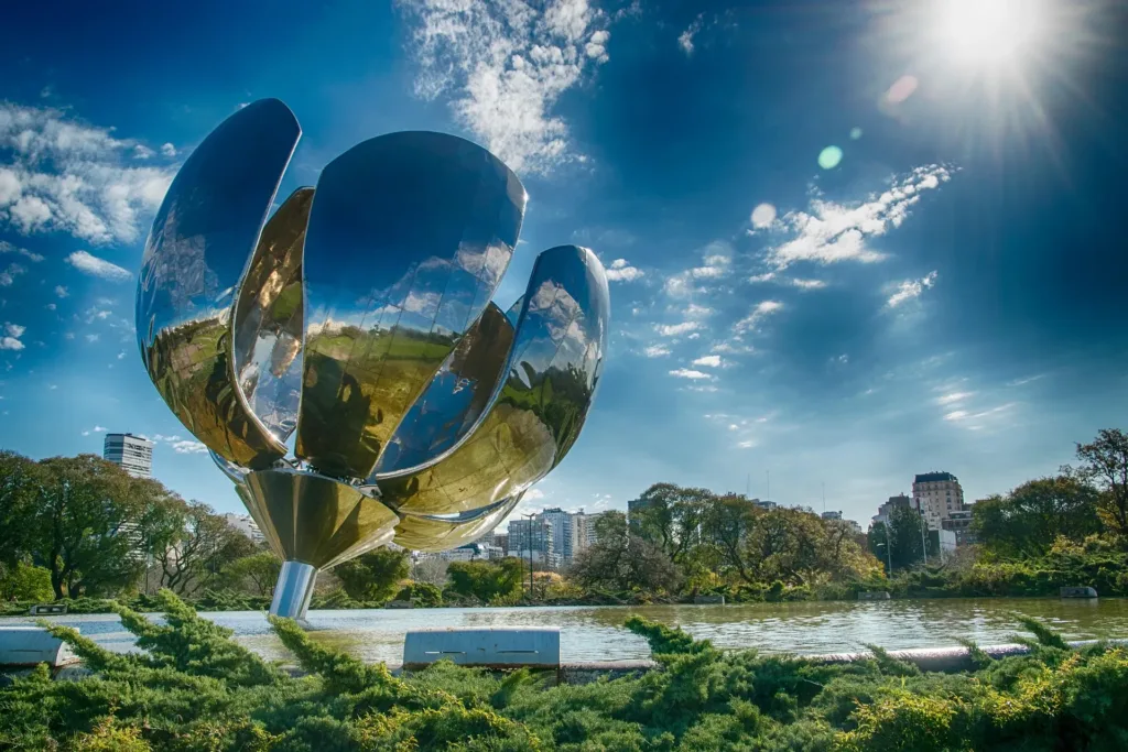Kovová plastika Floralis Genérica v parku u jezírka v Buenos Aires za slunečného dne.