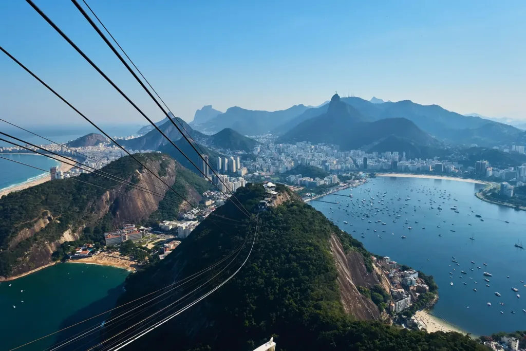 Pohled z lanovky na Cukrové homoli na zalesněné kopce, zátoku Botafogo a město Rio de Janeiro.