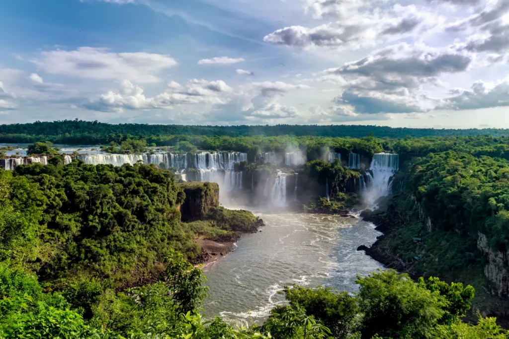 Široký pohled na vodopády Iguazú obklopené hustým zeleným pralesem