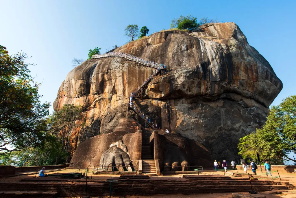 Schodiště vedoucí po skalním masivu Sigiriya kolem kamenných lvích tlap v tropické zeleni.